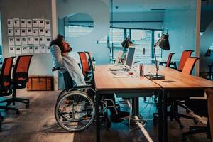 a man in a wheelchair sitting at a desk in an office photo