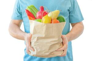 Shopping bag with food in mens hands photo