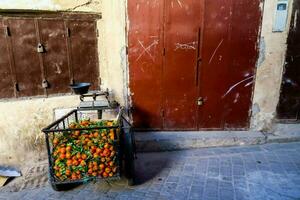 a cart with oranges on it sitting in front of a door photo