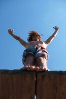 a man is standing on a wooden ledge photo