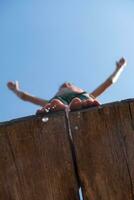 a man is standing on a wooden ledge photo