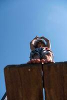 a man is standing on a wooden ledge photo