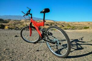 un rojo montaña bicicleta estacionado en el lado de el la carretera foto
