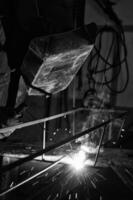 a black and white photo of a man welding