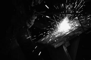 a black and white photo of a man welding
