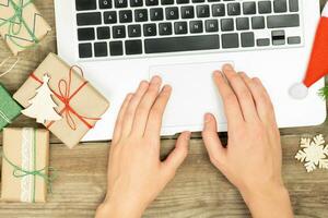 Christmas background with hands and laptop. Online shopping concept. photo