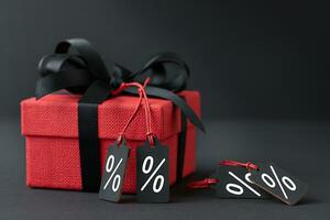 Red gift box with labels on black background photo