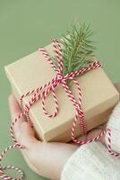 Christmas holiday box with red ribbon in hands photo