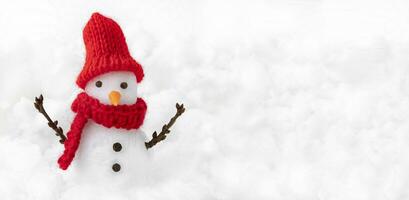 Snowman in red hat on winter snowing background photo