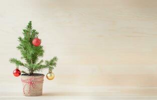 Decorated potted Christmas tree on the wooden background photo