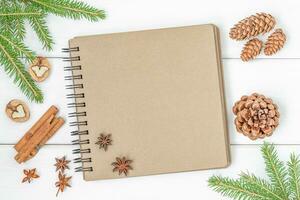 Christmas composition with notebook, cones, cinnamon, nuts and twigs of spruce photo