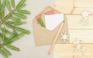 Christmas composition with envelope, pencil, paper, spruce and toys photo