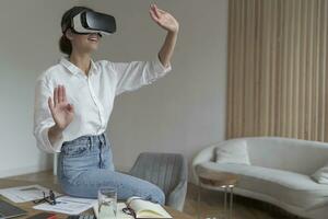 Engaged female experiencing virtual reality with headset in a modern workspace photo
