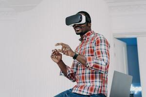 Man in plaid shirt experiencing VR technology, interacting with virtual space photo