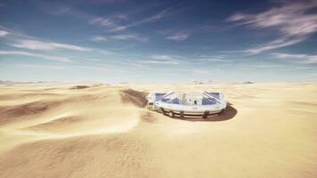 Giant round glass edifice amidst a sandy expanse photo