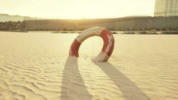 Lifebuoy on the city beach at sunset photo