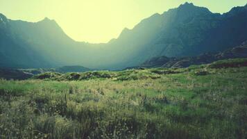 dry rugged mountain terrain with sparse vegetation and many rocks photo