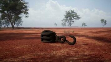 A rusty metal hook on a vibrant red dirt road photo