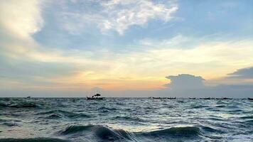 fishing boats during sunset sky at beach landscape, fishing boats during a sunrise or sunset, shimmering of the sun on the clouds,the sky and clouds have the power to inspire feelings of awe or wonder video