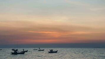 fishing boats during sunset sky at beach landscape, fishing boats during a sunrise or sunset, shimmering of the sun on the clouds,the sky and clouds have the power to inspire feelings of awe or wonder video