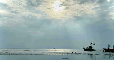 pescaria barcos durante pôr do sol céu às de praia paisagem, pescaria barcos durante uma nascer do sol ou pôr do sol, cintilante do a Sol em a nuvens, o céu e nuvens ter a poder para inspirar sentimentos do temor ou maravilha video