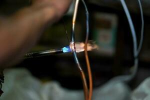 Closeup builder using gas welding to connect the refrigerant pipe. photo