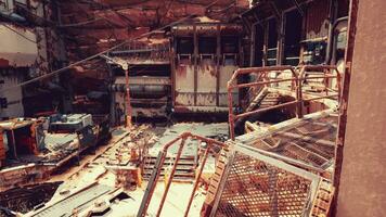 A dilapidated building with rusted metal debris scattered on the ground photo