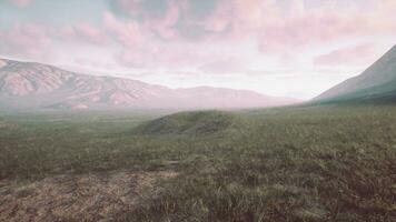 A picturesque field with majestic mountains as the backdrop photo