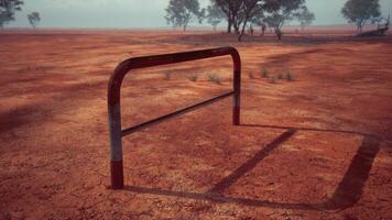 un rústico rojo suciedad campo con un encantador cerca y arboles en el antecedentes foto