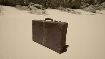 A piece of luggage sitting on top of a sandy beach photo