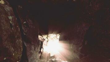 Shaft of light beaming down into large cave photo