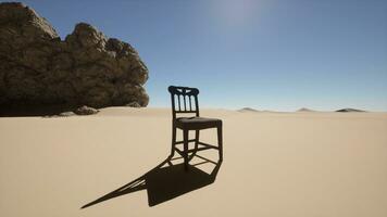 A chair sitting in the middle of a desert photo