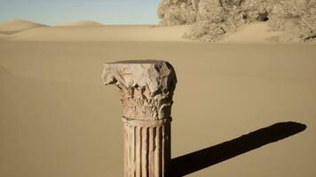 A stone column in the middle of a desert photo