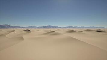 A desert landscape with sand dunes and mountains in the distance photo