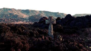 A cemetery cross standing tall amidst a breathtaking mountain range photo