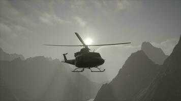 A helicopter is flying over a mountain range photo