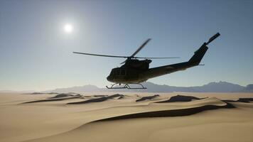 A helicopter is flying over a desert landscape photo