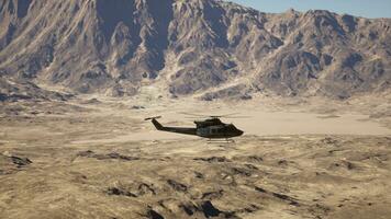 A helicopter flying over a mountain range in the desert photo