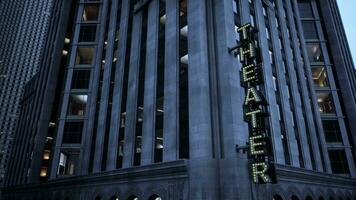 A towering building with a vibrant neon sign illuminating the night sky photo