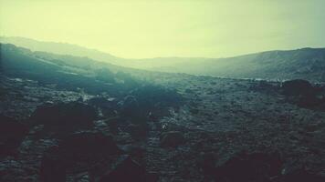 amanecer en un desierto rocoso con sombras proyectadas por las colinas foto
