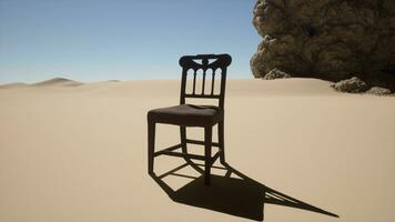 A chair sitting in the middle of a desert photo