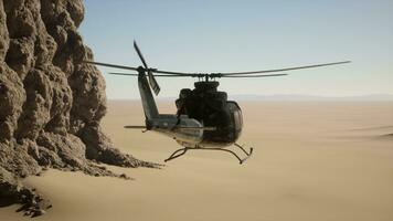 A helicopter flying over a rocky cliff in the desert photo