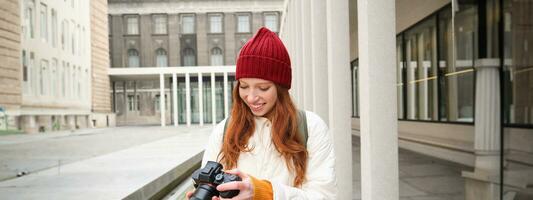 hermosa cabeza lectora chica, fotógrafo con profesional cámara toma imágenes al aire libre, caminando alrededor ciudad y tomando fotos, Turismo foto