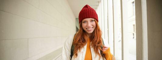 Young tourist, happy girl walking around european city with backpack, student goes to university, goes somewhere in town photo