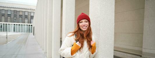 Happy redhead girl, tourist going around town, exploring sighsteeing places in city, backpacking around europe, enjoys travelling photo