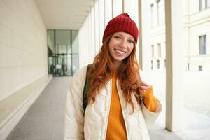 Young tourist, happy girl walking around european city with backpack, student goes to university, goes somewhere in town photo