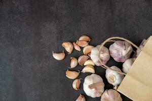 Big and small heads of garlic on a black background. photo