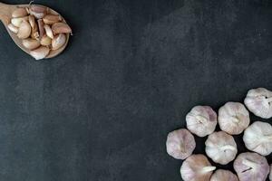 Big and small heads of garlic on a black background. photo