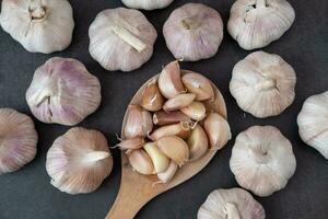 Big and small heads of garlic on a black background. photo