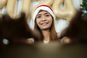 Merry Christmas 2024 concept Asian woman opens box and picks up gift in Christmas box photo